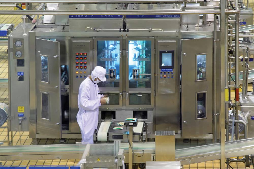 Food technician in a lab around machinery 1